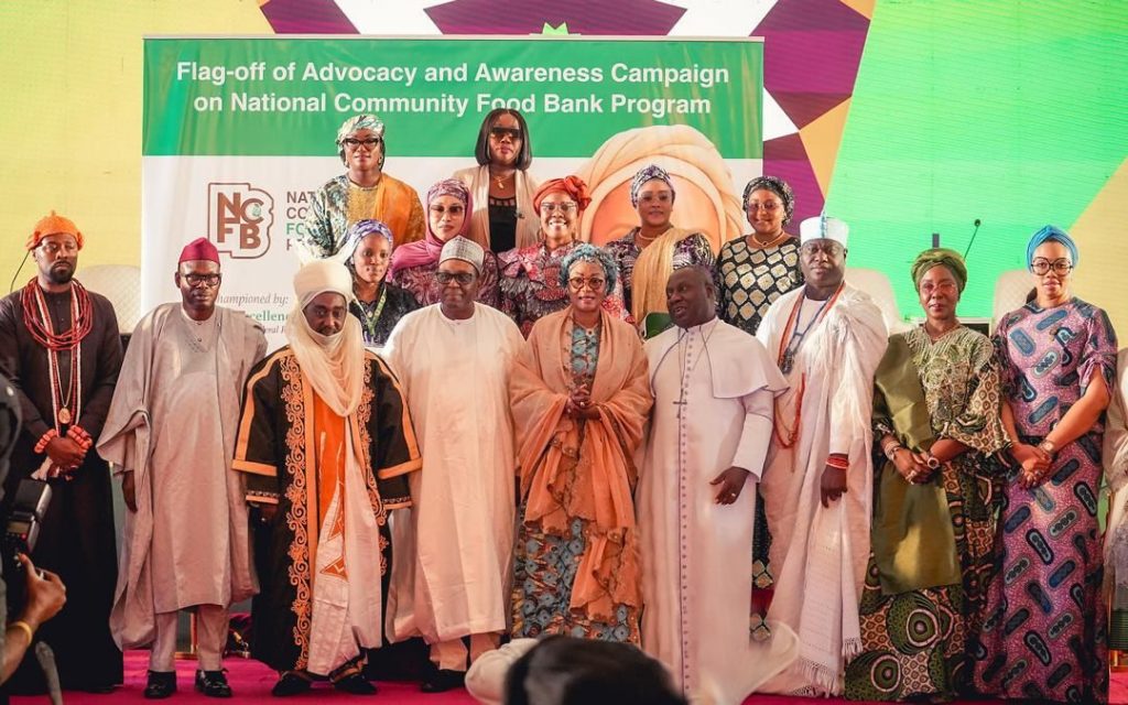First Lady Senator Oluremi Tinubu, CON, and dignitaries pose on stage in front of a banner for the National Community Food Bank Program.