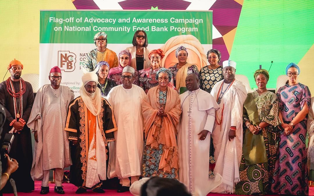 First Lady Senator Oluremi Tinubu, CON, and dignitaries pose on stage in front of a banner for the National Community Food Bank Program.