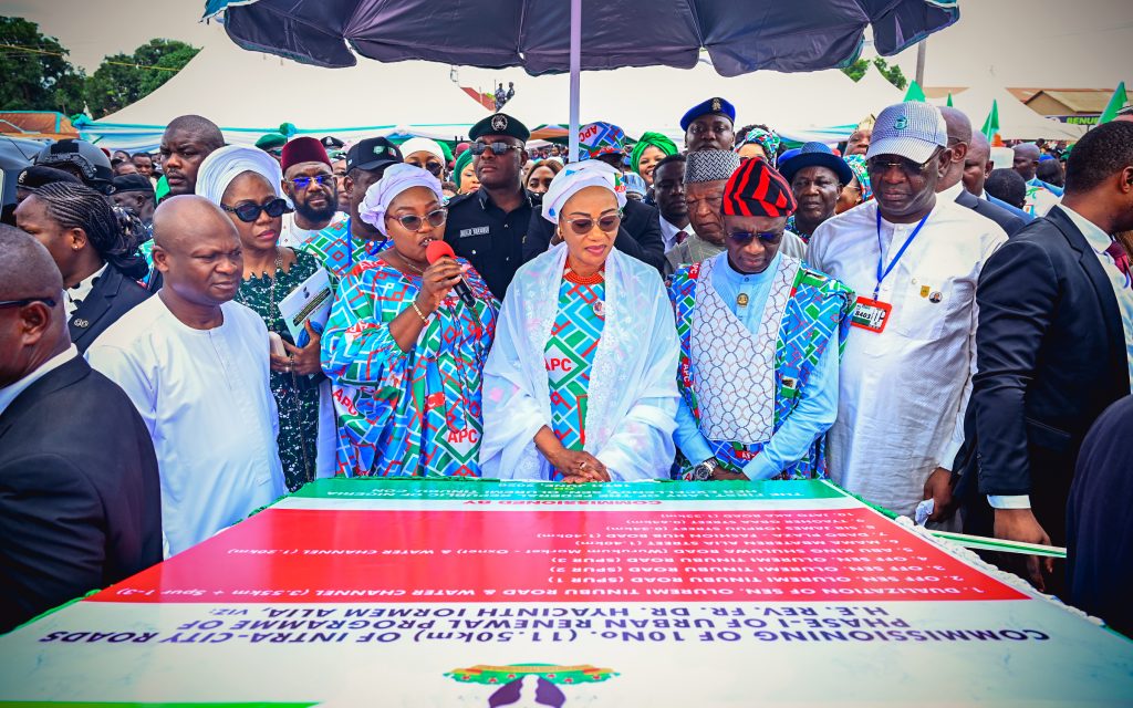First Lady Senator Oluremi Tinubu, CON, alongside Benue State Governor Hyacinth Alia and other officials, looking at a large commemorative plaque during a road commissioning ceremony outdoors