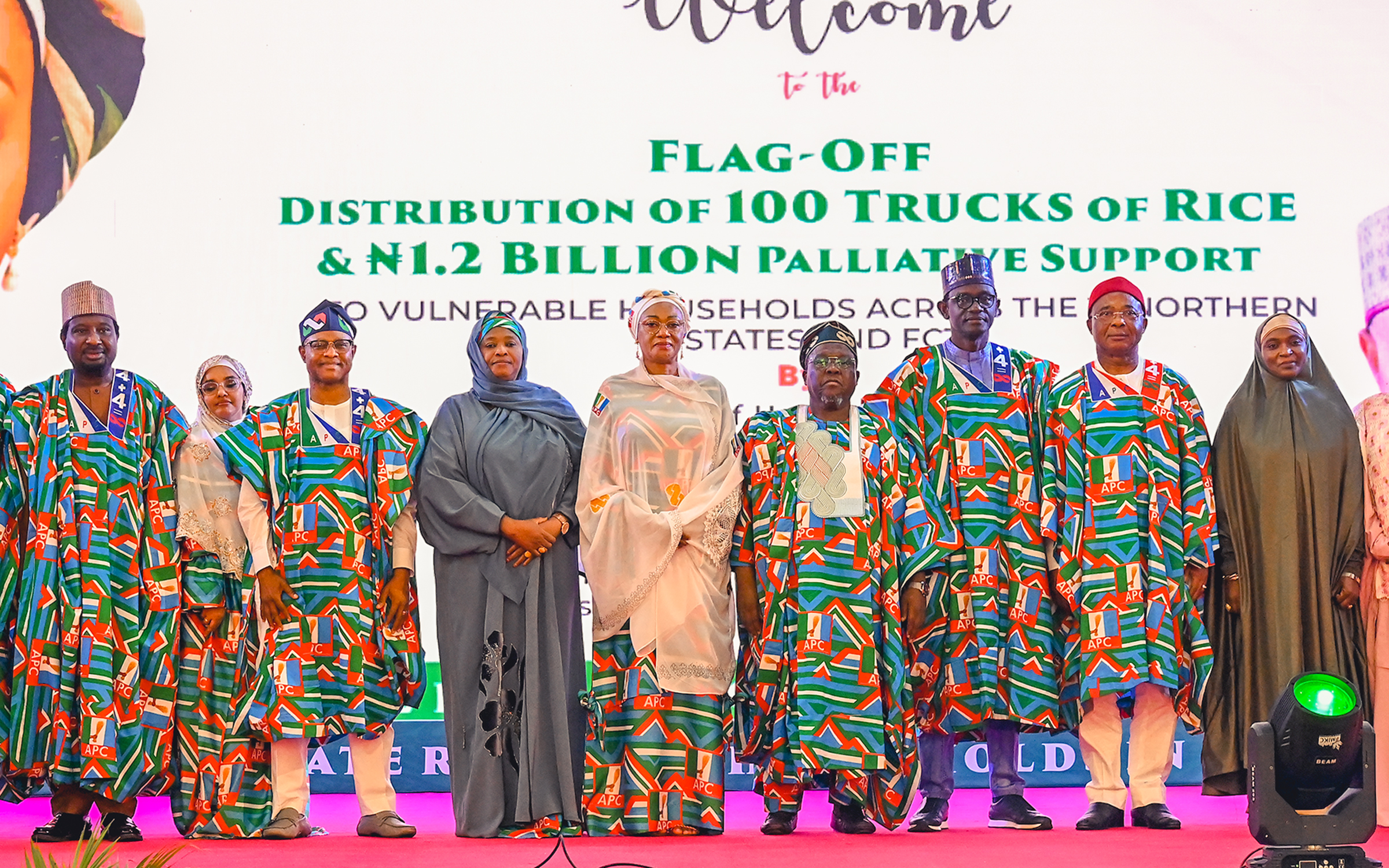 First Lady Senator Oluremi Tinubu, CON, and government officials standing on stage in front of a banner detailing the distribution of 100 trucks of rice and palliative support.