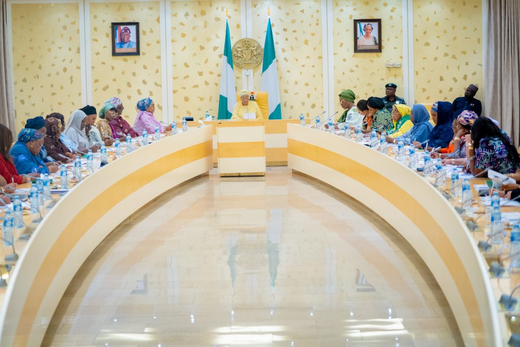 First Lady Senator Oluremi Tinubu, CON, presiding over an official meeting seated at the head of a large conference table.