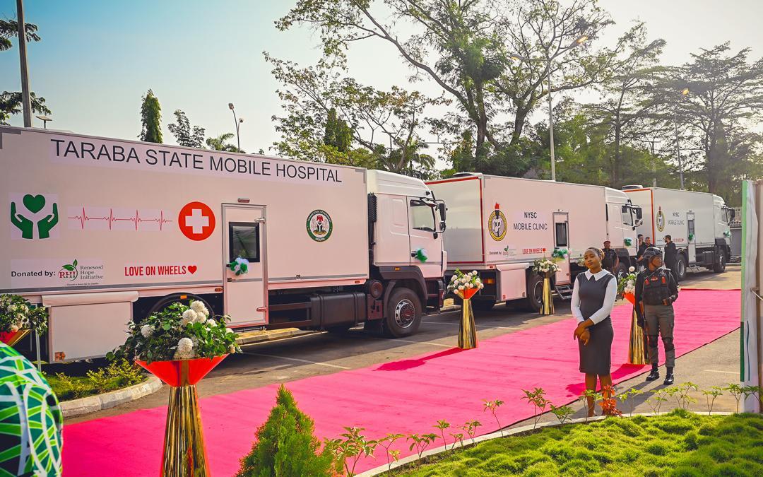 Taraba State Mobile Hospital trucks parked along a red carpet during a commissioning or handover event.
