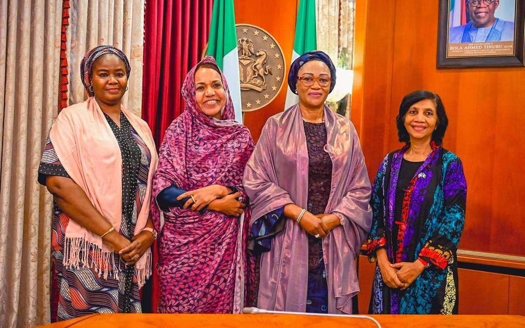 First Lady Senator Oluremi Tinubu, CON, posing for a group photograph with female officials indoors.