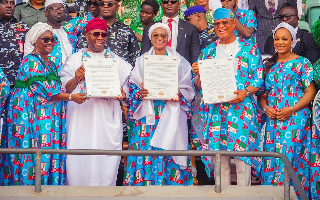 First Lady Senator Oluremi Tinubu, CON, and political leaders holding up official documents while dressed in matching party attire.