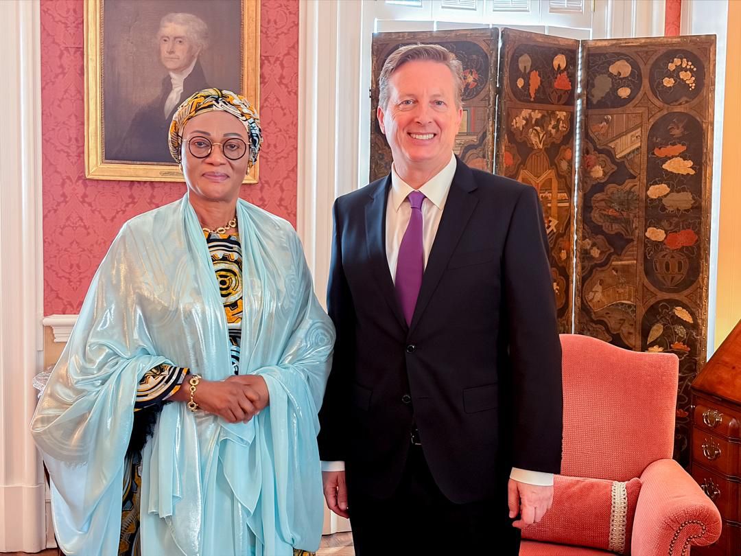 First Lady Senator Oluremi Tinubu, CON, posing for a photo alongside a man in a dark suit and purple tie.