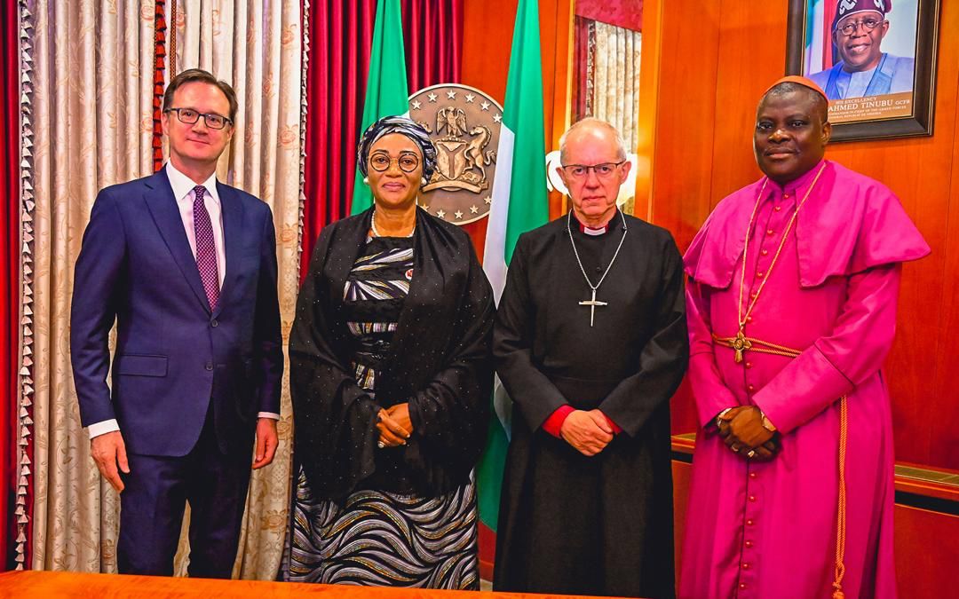 First Lady Senator Oluremi Tinubu, CON, posing for a group photograph alongside four male dignitaries, including two in clerical attire.