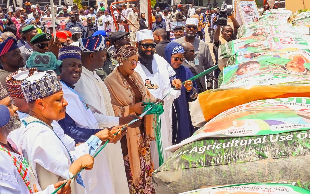 First Lady Senator Oluremi Tinubu, CON, and officials cutting a ceremonial ribbon near large agricultural bags.